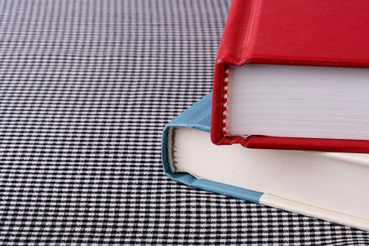Two books on a table covered with a cloth in a white and black section.