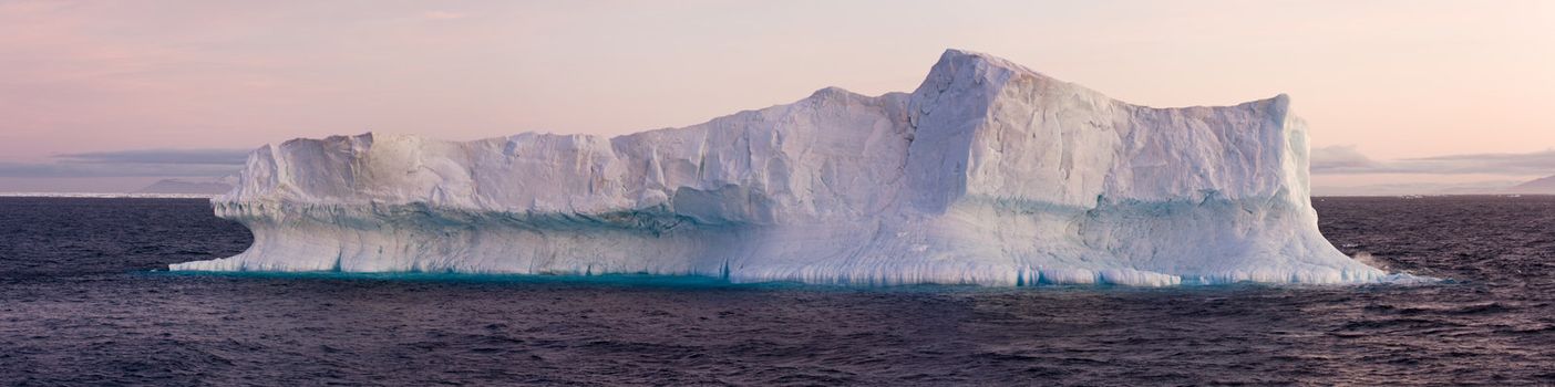 Large iceberg floating in sea. Horizontally framed shot.