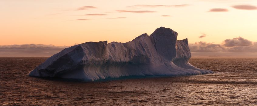 Large iceberg floating in sea at dusk. Horizontally framed shot.