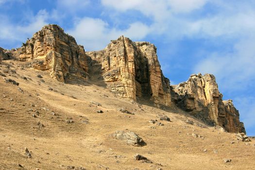 Yellow rocks in the Caucasian mountains on a background of the blue sky