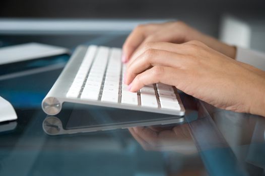 A woman hands typing on a computer keyboard
