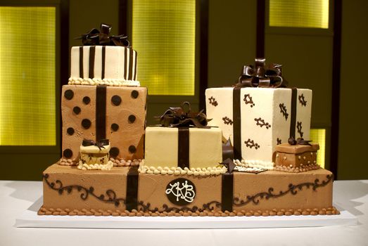 Image of a brown and white wedding cake with multiple layers, polka dots, and stripes