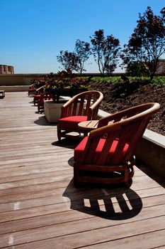 Image of several wooden patio chairs on a deck