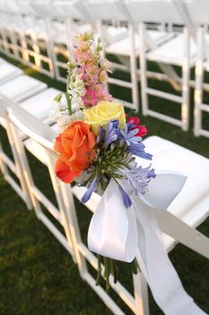 Image of a floral bouquet on a row of white chairs
