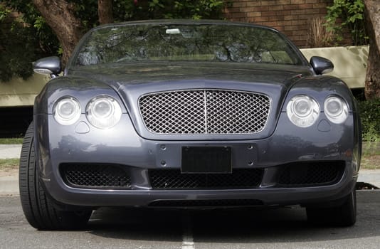 Front Of A Blue Metallic Large Car On A Street