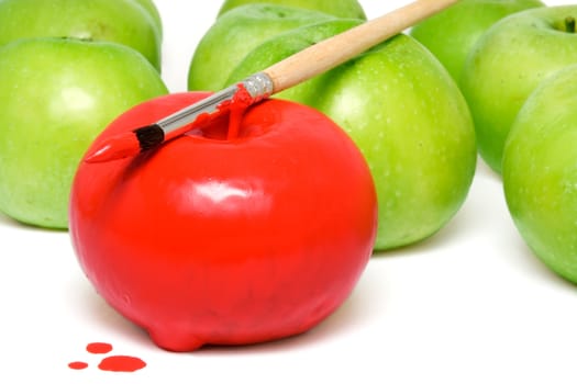 The apple painted by a red paint among unpainted apples