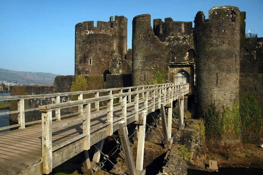 Caerphily castler as seen from a distance across a bridge   