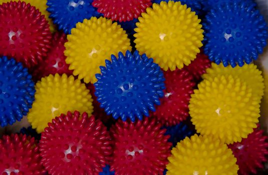 A box of blue, yellow and red balls. The balls have nips or stubs.