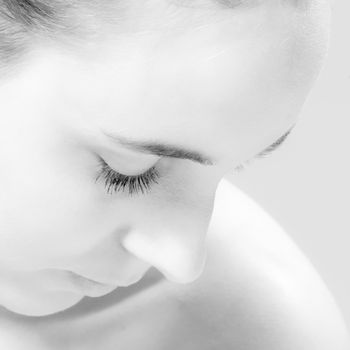 Studio close up portrait of a beautiful woman looking down