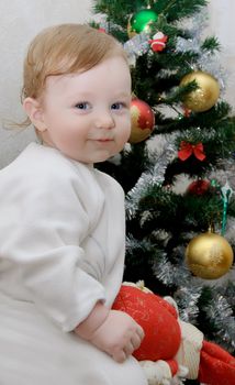 Adorable baby boy on Christmas tree background