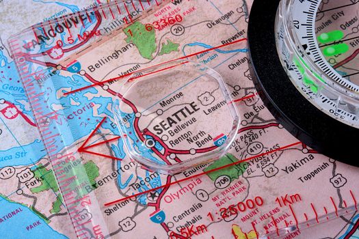 USA map with the city of Seattle and a compass with magnifying glass over Seattle.