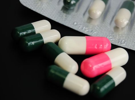 drugs or vitamines? seven capsules on black