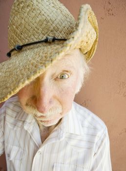 Senior Citizen Man with a Funny Expression Wearing a Straw Cowboy Hat