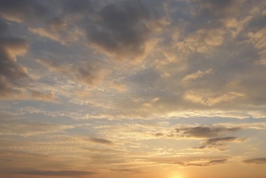 Cloudy sky is in the sunset rays of a sun