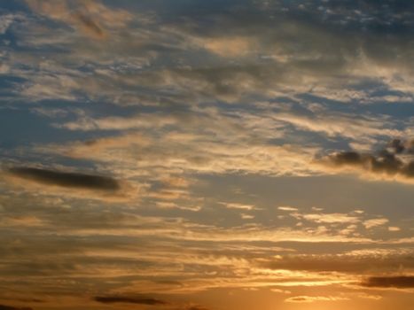 Cloudy sky is in the sunset rays of a sun  