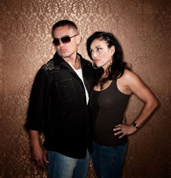 Attractive Hispanic Couple Posing in Front of Gold Wallpaper