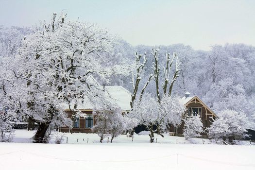 A small farm in a frosted winter landscape