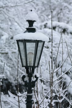 A vintage lantern covered in snow