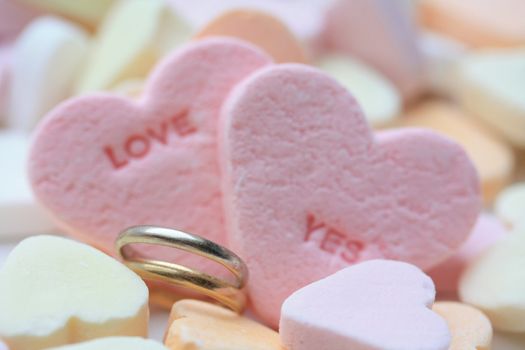 A set of wedding bands and valentine candy hearts, love yes