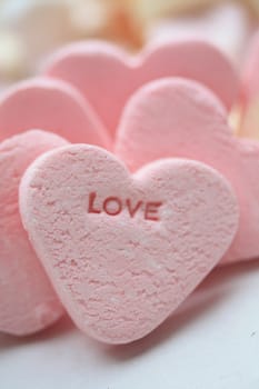 A pink valentine candy heart with the word love