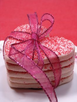 Heart shaped cookies stacked and tied with ribbon.