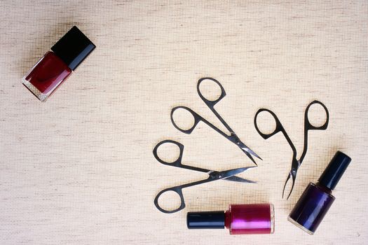 The special tool for care of nails with a small bottle red a varnish against from a fabric.
