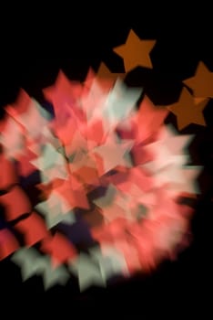 a pattern of bokeh star shapes created at a fireworks display