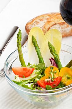 glass bowl of fresh salad with green asparagus