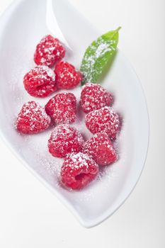 raspberries with icing sugar on a plate