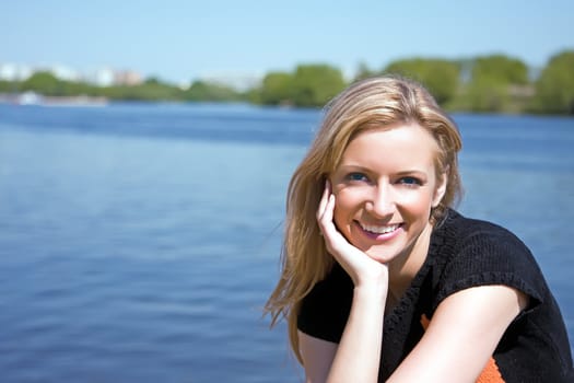 The beautiful girl on the bank of the summer river