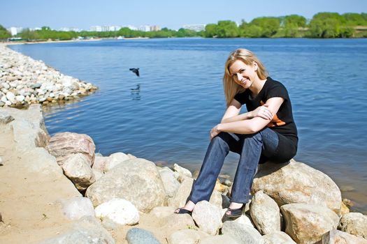 The beautiful girl on the bank of the summer river