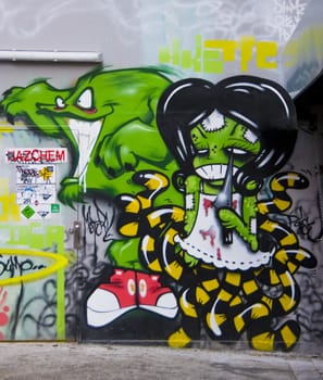 Graffiti green monster with green faced scary multilegged monster girl in urban alley in Melbourne Australia. 