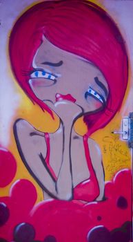 Sad girl in pink on wall painting in urban alley in Melbourne Australia. Nice graffiti, unblemished cartoon like figure.