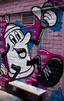 Graffiti black & white coffee pot on pink wall in Melbourne Australia in urban alley, unblemished.
Cartoon figure