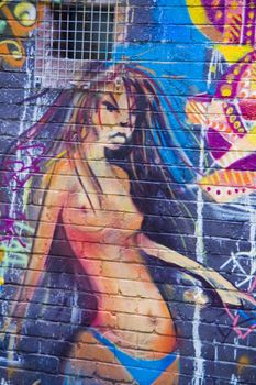 Graffiti angry girl in monokini on blue wall in an urban alley in Melbourne Australia. Unblemished figure.