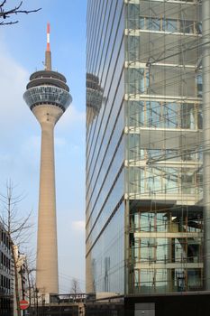 Modern glass skyscraper on background with blue sky and radio tower in Dusseldord, Germany