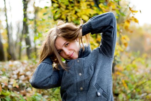 beautiful girl in the woods with her hands behind head and flowing hair