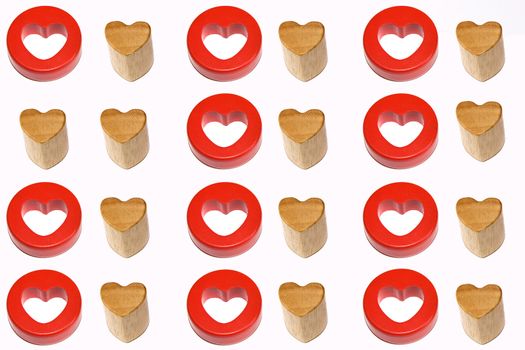 Two identical wooden hearts surrounded by couples of red and wooden hearts