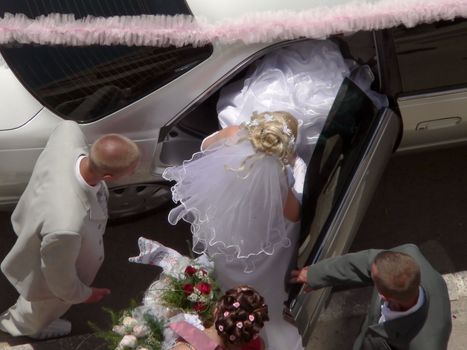 Bride sitting to car