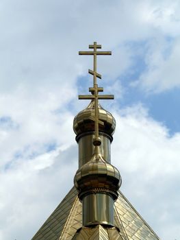 Cross on the churches dome on clouds background