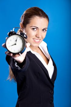 Portrait of a beautiful and young businesswoman holding an hold clock, focus on the model
