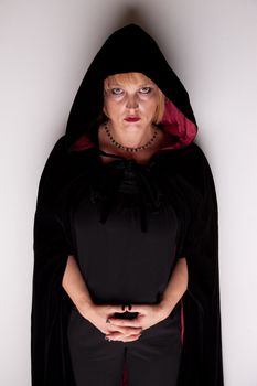 Female witch in dark robe with hood