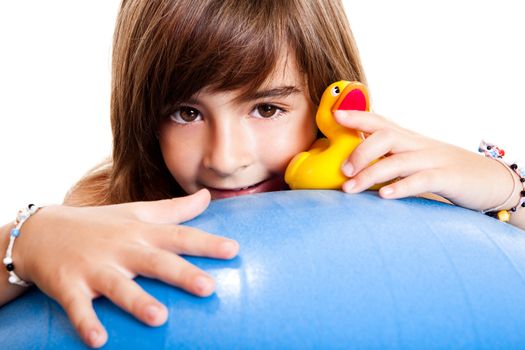 Happy little child smilling and playing with a yellow rubber duck
