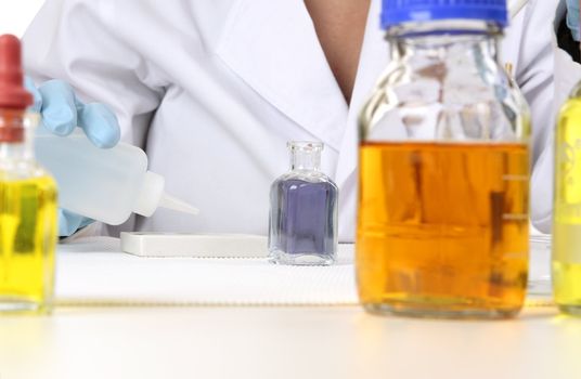 Closeup of a laboratory worker using a spotting plate and dropper bottle during research.  Focus to those items.