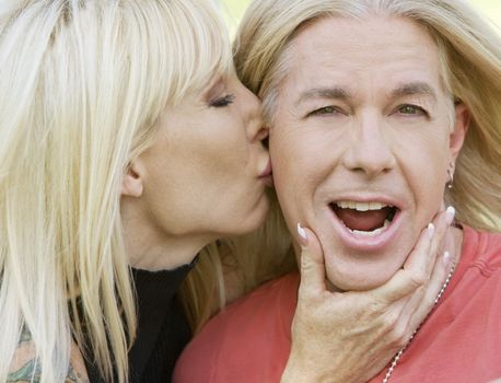 Outdoor portrait of a woman kissing a man