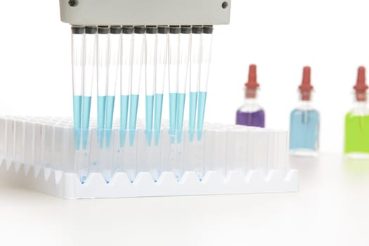 Pipette releases a programmed amount of fluid into laboratory cuvettes.  Focus to foreground 