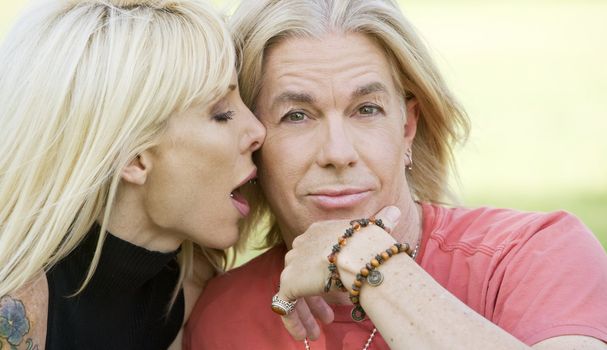 Outdoor portrait of a woman kissing a man