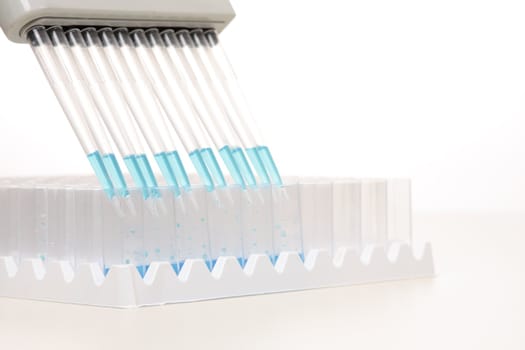 Electronic pipettors can be programmed to aspirate, mix and dispense variable volumes.  When dispensing it is recommended the pipette be held at a 45 degree angle.  Focus to foreground shallow dof with copyspace.