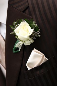 A closeup of a dark brown tuxedo; lapel area.  Brown tuxes are all the rage in the wedding industry right now.