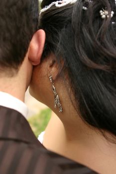 A wedding couple embraces cheek to cheek.